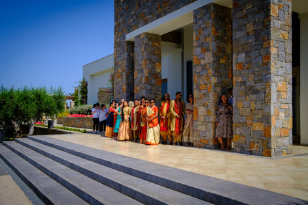 in front of the hotel a colorfully dressed indian wedding party is waiting for the arrival of the bride and groomのeditorial素材