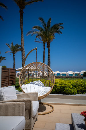 a relaxing armchair stands on a terrace next to the beachの写真素材