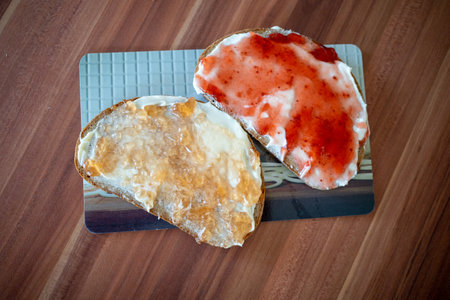 on a breakfast board are two jam sandwichesの写真素材