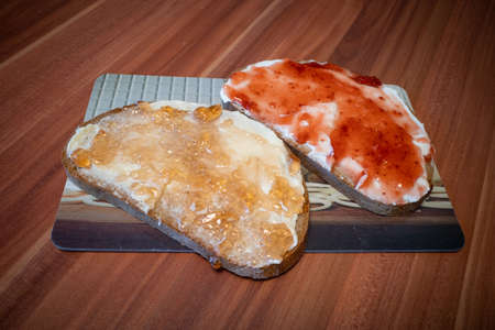 on a breakfast board are two jam sandwichesの写真素材