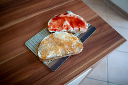 on a breakfast board are two jam sandwichesの写真素材