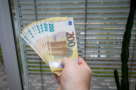next to the gas meter is held a lot of two hundred euro banknotesの写真素材