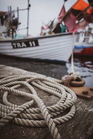 a ship is attached to a bollard in the harbor with a thick ropeの写真素材