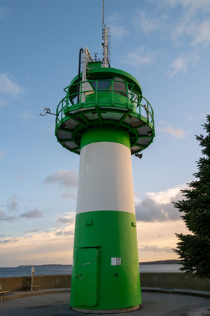 the green-white lighthouse in the harbor of Luebeck Travemuendeの写真素材