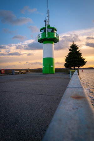 the green-white lighthouse in the harbor of Luebeck Travemuendeの写真素材