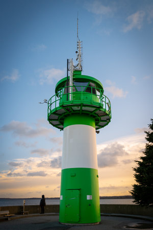 the green-white lighthouse in the harbor of Luebeck Travemuendeの写真素材