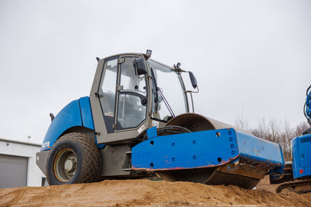 Gravel is compacted with a bulldozer at a construction siteの写真素材