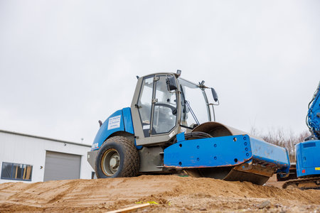Gravel is compacted with a bulldozer at a construction siteの写真素材