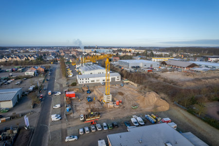 a large yellow construction crane and various construction machines are used on a construction siteの写真素材