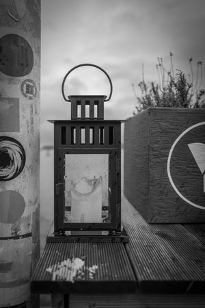 a lantern with a candle stands on a table in black and whiteの写真素材