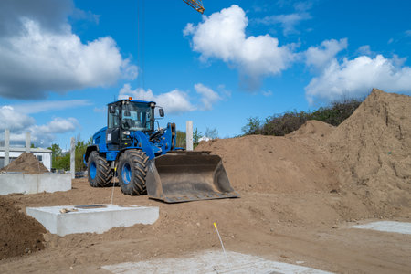 a big blue wheel loader stands on a construction siteの写真素材