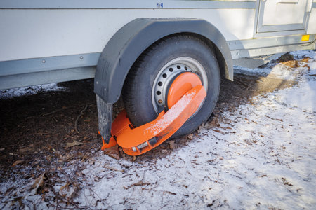 an immobilizer from the public order office is attached to one wheel of a trailerの写真素材