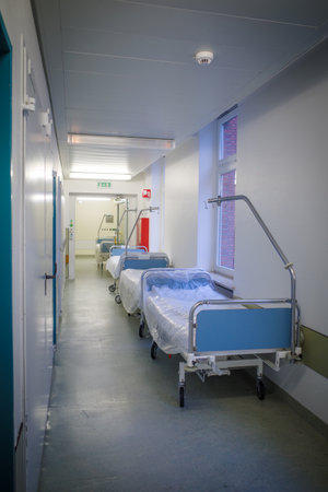 some empty beds stood in a hospital corridorの写真素材