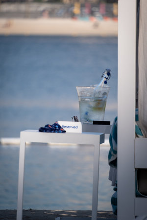 There is a bottle of sparkling wine in a cooler on the beachの写真素材