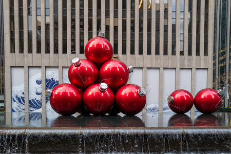 A fountain in New York is decorated with giant red Christmas tree baublesの写真素材