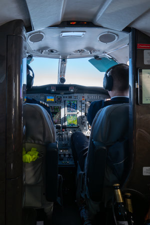 The pilots of a private jet sit in the cockpit