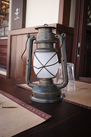 An old lantern stands decoratively on the tableの写真素材
