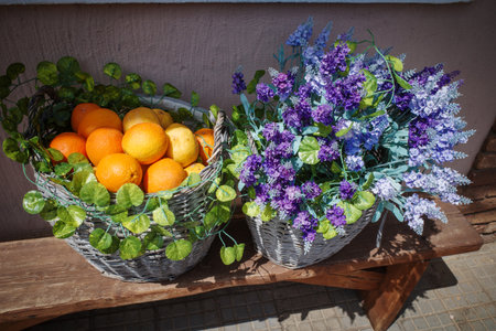 on a bench is a basket filled with lavender and orangesの写真素材