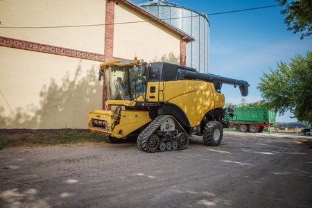 a huge yellow combine harvester stands on a farmの写真素材