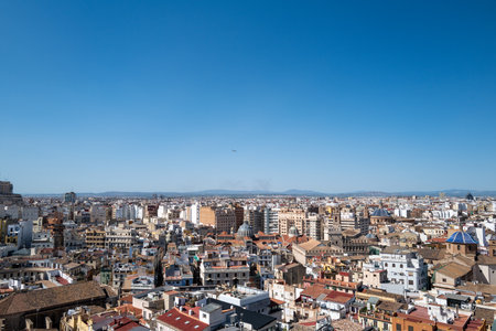 Aerial panoramic view of Valencia, Spain, showcasing the historic old town with its traditional Mediterranean architecture, colorful rooftops, and iconic blue-domed churches under a clear blue sky. The vibrant urban landscape highlights the unique blend of cultural heritage and modern city life, making it a popular travel and tourism destination on the Spanish Mediterranean coast.の写真素材