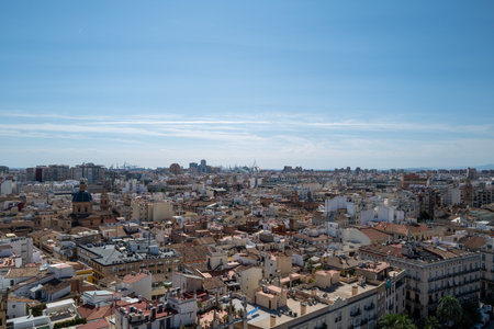 Aerial panoramic view of Valencia, Spain, showcasing the historic old town with its traditional Mediterranean architecture, colorful rooftops, and iconic blue-domed churches under a clear blue sky. The vibrant urban landscape highlights the unique blend of cultural heritage and modern city life, making it a popular travel and tourism destination on the Spanish Mediterranean coast.の写真素材