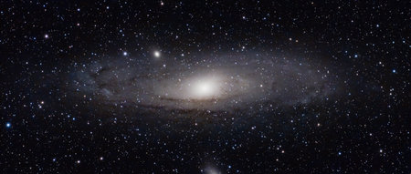 A stunning high-resolution photograph of the Andromeda Galaxy (M31), showing its magnificent spiral arms, glowing galactic core, and countless surrounding stars. This breathtaking deep space image captures the vastness and beauty of the universe, perfect for illustrating astronomy, astrophotography, cosmology, and the wonders of the night sky.の写真素材