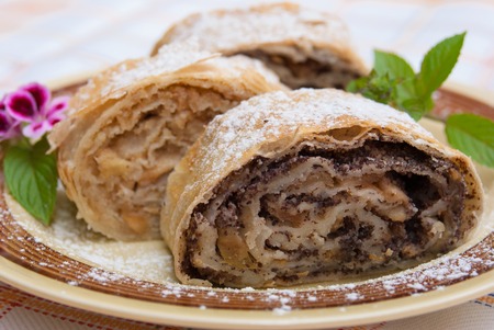 An apple strudel served on colored plate with some green decorationの写真素材