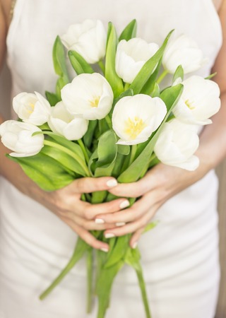 Young woman holding a bouquet of white tulips. Wedding bouquet. Spring. Bride.の写真素材
