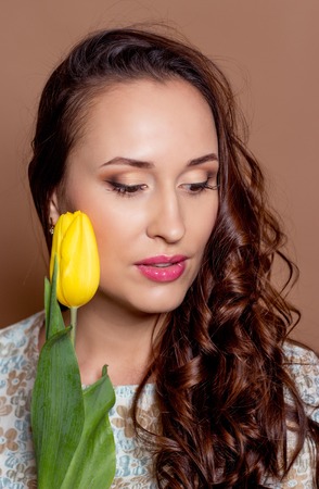 Young beautiful woman holding a bouquet of yellow tulips. Spring.の写真素材