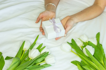 Womens open hands gift box. A bouquet of white tulips.の写真素材
