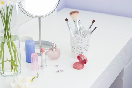 Cosmetics and a bouquet of flowers on the dressing table.の写真素材