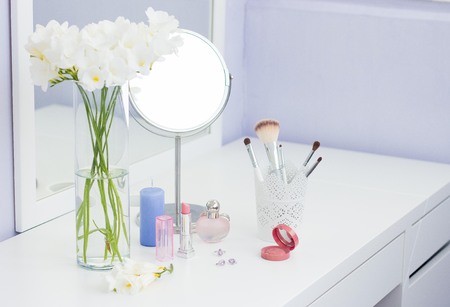 Cosmetics and a bouquet of flowers on the dressing table.の写真素材