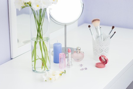 Cosmetics and a bouquet of flowers on the dressing table.の写真素材