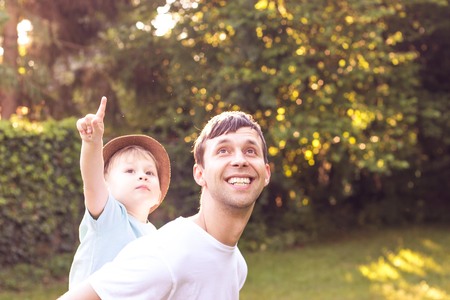 Father and son walk at sunset. Happy dad and young son in the Sun.の写真素材