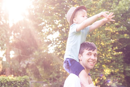Father and son walk at sunset. Happy dad and young son in the Sun.の写真素材