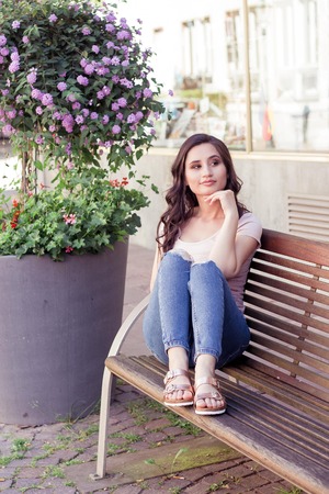 Young beautiful woman brunette walks at the city in Europe. Summer. Happy girl. Street fashion.