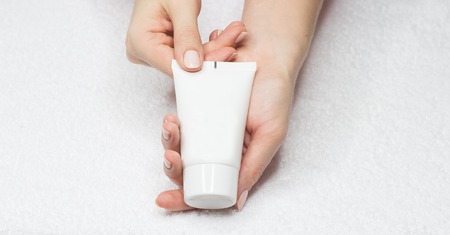 Girl gets a hand cream. Beautiful female hands and hand cream.の写真素材