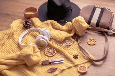 Autumn. Cozy. Knitted warm clothes. Home comfort. Warm autumn. Sweaters and hat on a wooden background. Winter.の写真素材