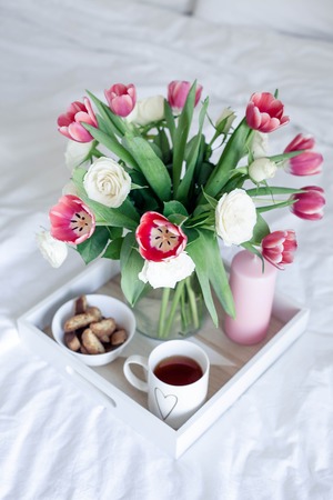 Romantic breakfast in bed. Bouquet of flowers. Roses and tulips. Spring. Valentine's Day....