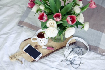 Romantic breakfast in bed. Bouquet of flowers. Roses and tulips. Spring. Valentine's Day. International Women's Day. Cozy. Summer.の写真素材