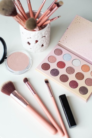 Cosmetics. Makeup. Dressing table. Home decor. Candle, eyeshadow, makeup brushes lipstick powder Radiance Pink gold Makeup toolsの写真素材