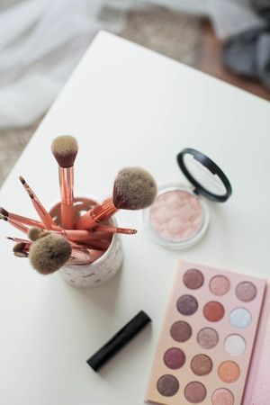 Cosmetics. Makeup. Dressing table. Home decor. Candle, eyeshadow, makeup brushes lipstick powder Radiance Pink gold Makeup toolsの写真素材