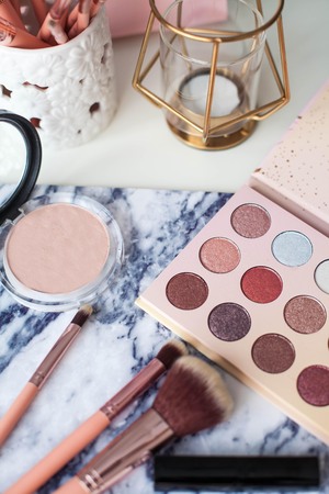 Cosmetics. Makeup. Dressing table. Home decor. Candle, eyeshadow, makeup brushes lipstick powder Radiance Pink gold Makeup toolsの写真素材