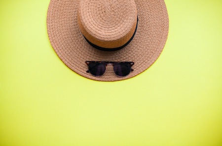 Summer beach accessories. Straw hat, sunglasses. Summer Bright Yellow backgroundの写真素材