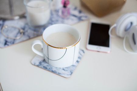 A cup of cappuccino, cosmetics, flowers, costume jewelry on a white table. Dressing table. Cozy. Springの写真素材