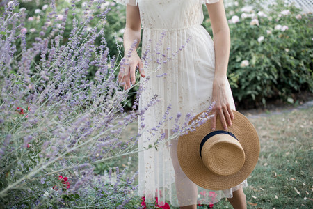 Female hands and lavender. A young woman is holding flowers and a straw hat. Purple. Summer.の写真素材
