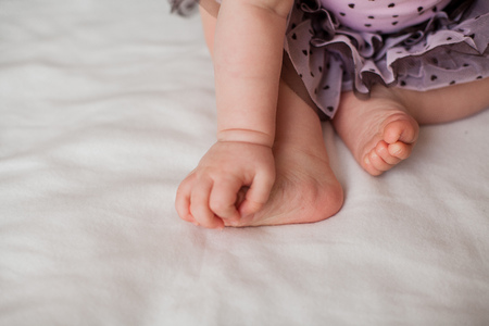 Close-up. Baby feet and handles 10 months. Cozy. Care.