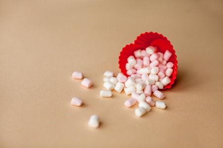 Red heart shape with marshmallows on beige background. Valentine's Day. Love.の写真素材