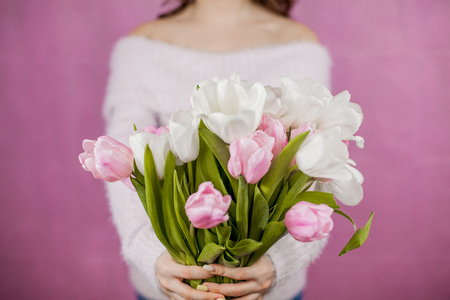 Close-up Young woman holding Bouquet of pink Tulips Pink background Spring Holidaysの写真素材
