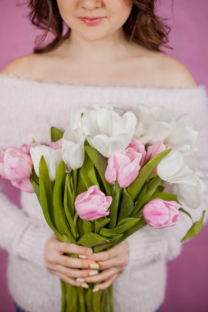 Close-up Young woman holding Bouquet of pink Tulips Pink background Springの写真素材
